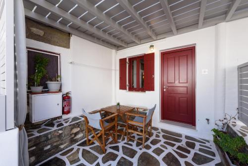 a patio with a table and a red door at Archipelagos Studios in Naousa