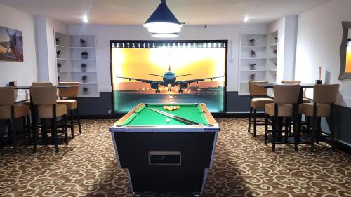 a pool table in a room with an airplane on the wall at Airport Hotel Manchester in Manchester