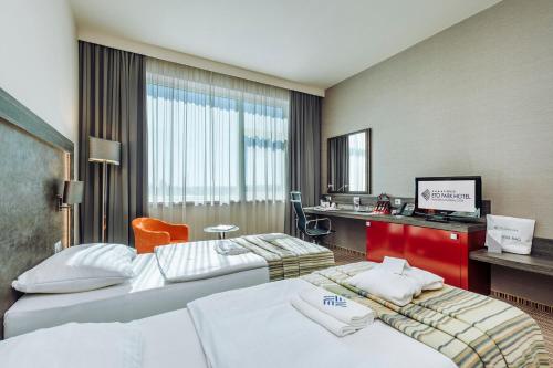 Pokój hotelowy z 2 łóżkami i biurkiem w obiekcie ETO Park Hotel Business & Stadium w Győr