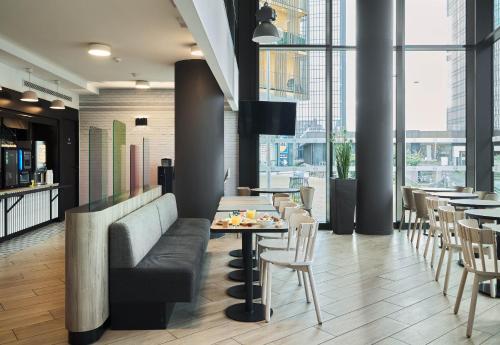 a restaurant with a couch and tables and chairs at B&B HOTEL Paris Porte de Bagnolet in Bagnolet