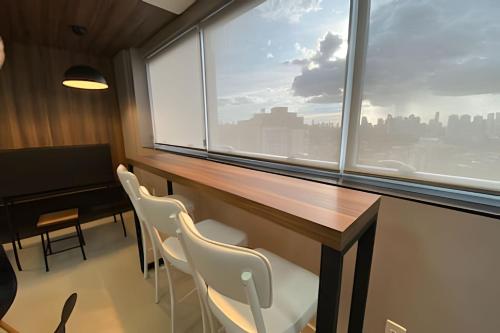a conference room with a table and chairs and a window at iFlat Brookfield Towers BT2103 Jardim Goiás in Goiânia
