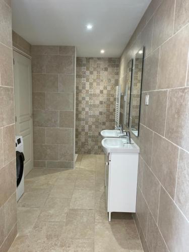 une salle de bain avec deux lavabos et un miroir dans l'établissement Longère cosy, à Saint-Maurice-lʼExil