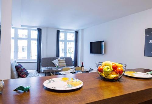 a living room with a table with a bowl of fruit on it at HITrental Zur Metzgern Apartments in Luzern