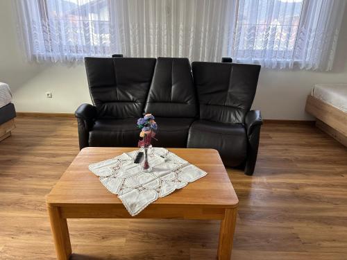 a living room with a leather couch and a coffee table at Villa Racing - Privatzimmer in Spielberg in Spielberg