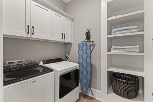 a kitchen with white cabinets and a stove at Hook, Wine & Sinker - 20 Couper Place in Mallory Park