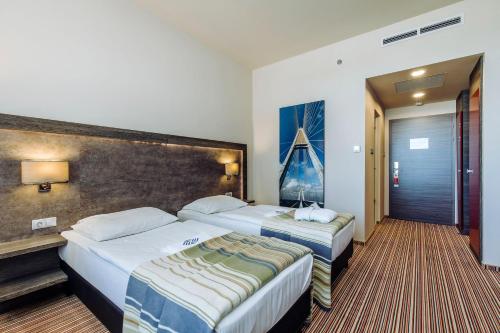 a hotel room with two beds in a room at ETO Park Hotel Business & Stadium in Győr