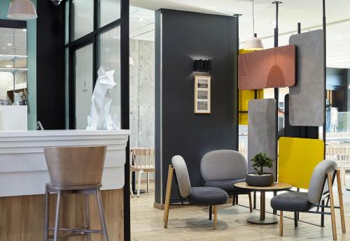 a lobby with chairs and a table and a counter at B&B HOTEL Saint-Denis Porte de Paris in Saint-Denis