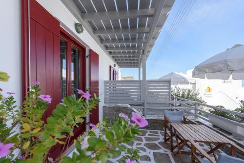 a balcony with benches and flowers on a building at Archipelagos Studios in Naousa
