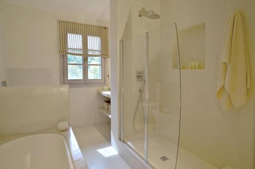 a white bathroom with a shower and a toilet at New Stylish Villa with Swimming Pool in Capalbio in Pescia Fiorentina