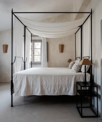 a bedroom with a large bed with a canopy at New Stylish Villa with Swimming Pool in Capalbio in Pescia Fiorentina