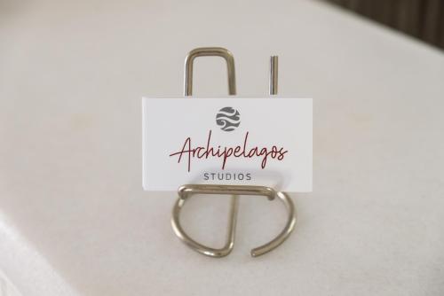 a sign for a shop with a gold handle at Archipelagos Studios in Naousa