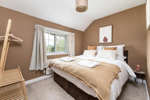 a bedroom with a large bed and a window at Central Malham Wellbeing Escape, 4-bed house with yoga studio in Malham