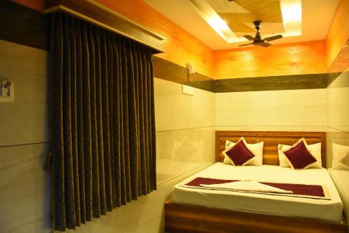 a bedroom with a bed and a ceiling fan at Vendha Sea Park in Velankanni