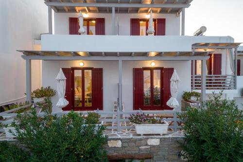 a white house with red doors and a porch at Archipelagos Studios in Naousa