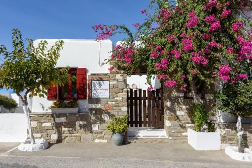 a building with pink flowers and a fence at Archipelagos Studios in Naousa