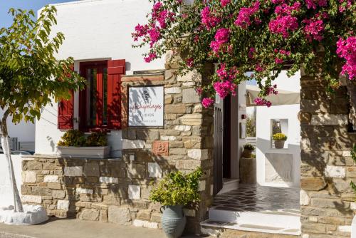 a house with pink flowers in front of it at Archipelagos Studios in Naousa