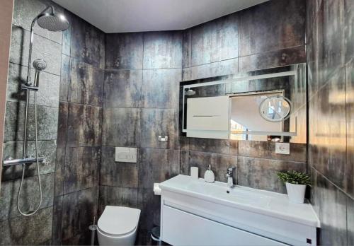 a bathroom with a sink and a toilet and a shower at Къща за гости Гардения in Kamburovo