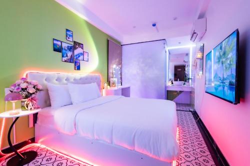 a bedroom with a large white bed and a bathroom at Cosy Hotel in Ho Chi Minh City