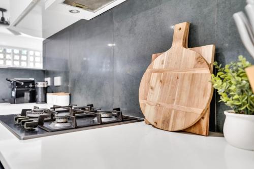a kitchen with a stove and a wooden cutting board at Woodland Retreat - Lower Haven in Stratford