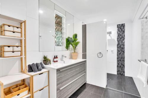a white bathroom with a sink and a shower at Woodland Retreat - Lower Haven in Stratford