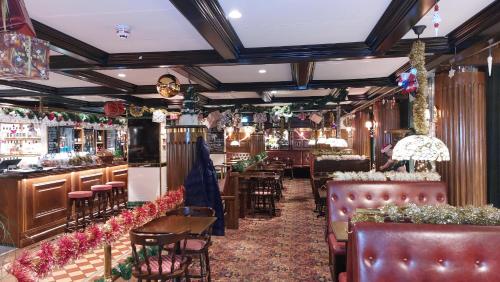 a restaurant with tables and chairs and a bar at Hotel Bishops Arms Mora in Mora