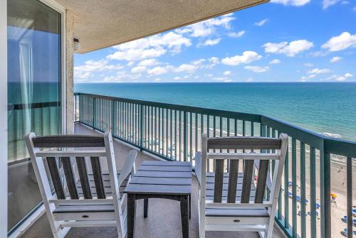 two chairs and a table on a balcony with the ocean at 4BR Oceanfront Corner Condo NMB in Myrtle Beach