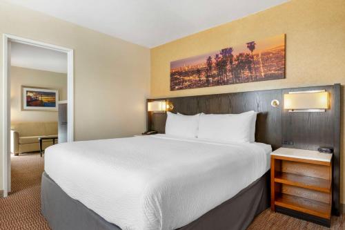 a hotel room with a large bed and a chair at Best Western Royal Palace Inn & Suites in Los Angeles