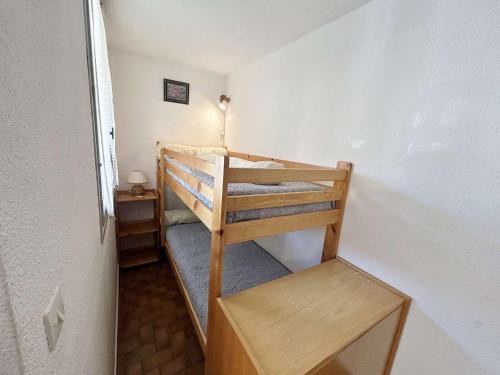Cette petite chambre comprend des lits superposés et une table. dans l'établissement T2 au cœur de Marseillan Plage avec terrasse, parking privé, proche commodités et animaux acceptés - FR-1-387-202, à Marseillan