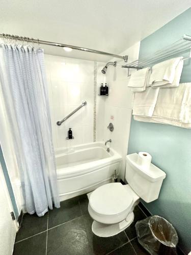 a bathroom with a toilet and a tub and a sink at ~Four-star serviced apartment in Honolulu