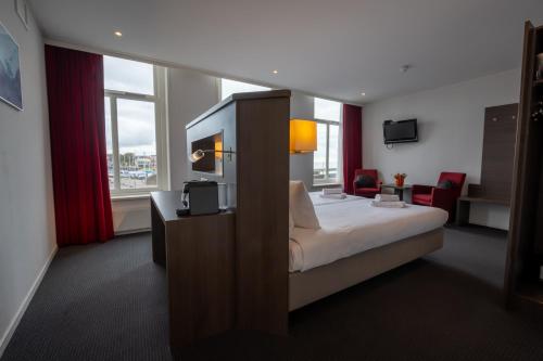 a hotel room with a bed and a television at Boutique Hotel Maldegem in Vlissingen