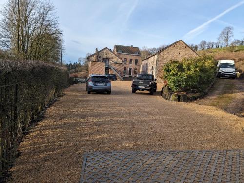 two cars driving down a road in front of a house at L'Air du Pré - loft 5p - Mariomont in Verviers