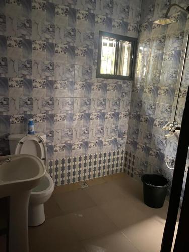 un baño con inodoro y lavabo en De Royal Lodge, en Lagos