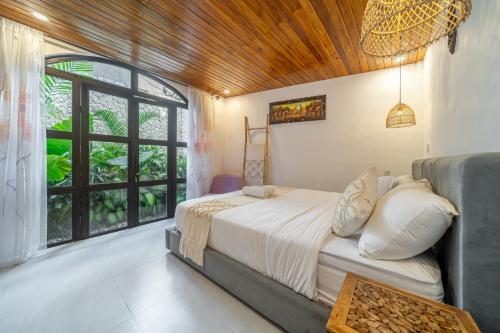 a bedroom with a bed and a large window at Darina - Brand-New Villa Just Minutes from the Beach with a Huge Pool in Badung