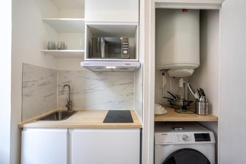 une petite cuisine avec un évier et un micro-ondes dans l'établissement La Clé - Clim - WiFi - Gare - Centre Toulon, à Toulon