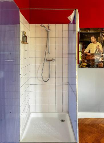 a bathroom with a shower with a white tiled wall at Cafe Modern in Amsterdam