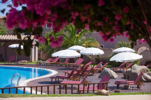 a group of chairs and umbrellas next to a swimming pool at Residence with swimming-pool in Campulongu just 600 mt from the sea in Campu Longu