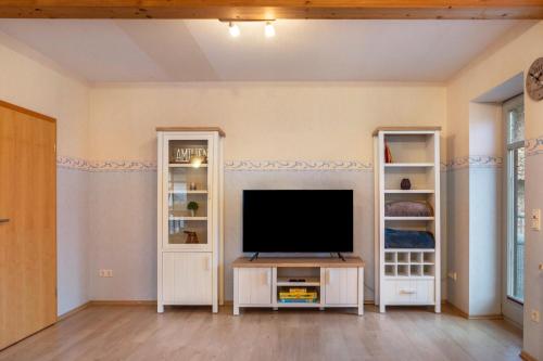 a living room with a television and shelves at Ferienwohnung 1 Hof Schäfer in Waldeck