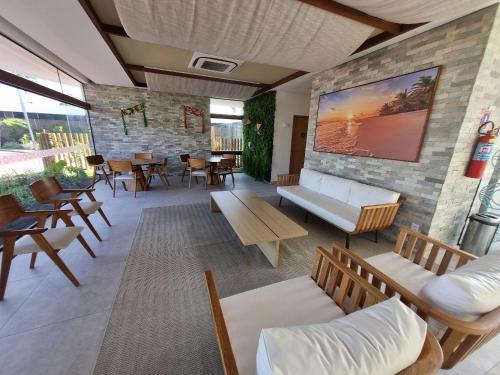 a waiting room with tables and chairs and a wall of windows at Flat em Muro Alto - Porto de Galinhas - MAKIA B117 - By Anfitrião Legal in Porto De Galinhas
