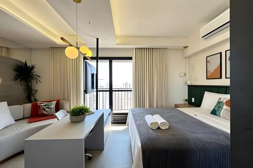 a bedroom with a large bed and a couch at iFlat iD Vida Nova 2803B Setor Oeste in Goiânia