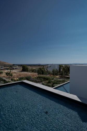 a swimming pool with a view of the ocean at PNOĒS Tinos in Tinos