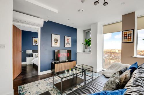 a living room with a blue accent wall at Last-Minute Escape l Sleeps Up to 6 l Stylish City Views Near Station by Capital Retreat Short lets & Serviced Accommodations in Merton