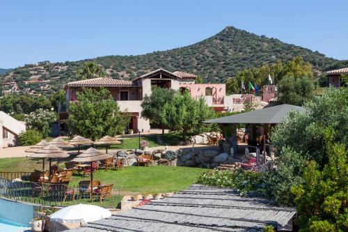 a resort with a pool and tables and chairs at Residence with swimming-pool in Campulongu just 600 mt from the sea in Campu Longu