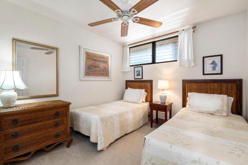a bedroom with two beds and a ceiling fan at Sea Village 4-205 in Kailua-Kona