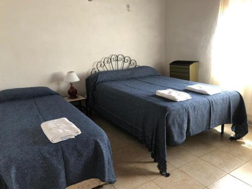 een slaapkamer met 2 bedden met blauwe lakens en handdoeken bij Hostería Michel in Villa Gesell