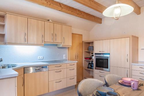 a kitchen with wooden cabinets and a table with chairs at Ferienwohnung 2 Hof Schäfer in Waldeck
