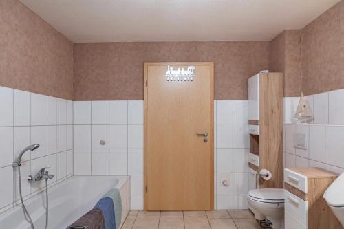 a bathroom with a bath tub and a toilet at Ferienwohnung 2 Hof Schäfer in Waldeck