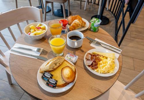 a table with plates of breakfast food on it at B&B HOTEL Bordeaux Centre Gare Saint-Jean in Bordeaux