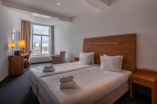 a hotel room with a large bed and a window at Boutique Hotel Maldegem in Vlissingen