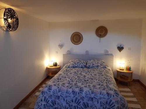 a bedroom with a blue and white bed with two lamps at Maison en Luberon in Sainte-Croix-à-Lauze