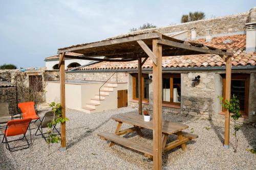 a wooden pergola and a picnic table in front of a house at Casa Comalats in Ametlla